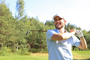 man in his 30s smiling at his golf shot